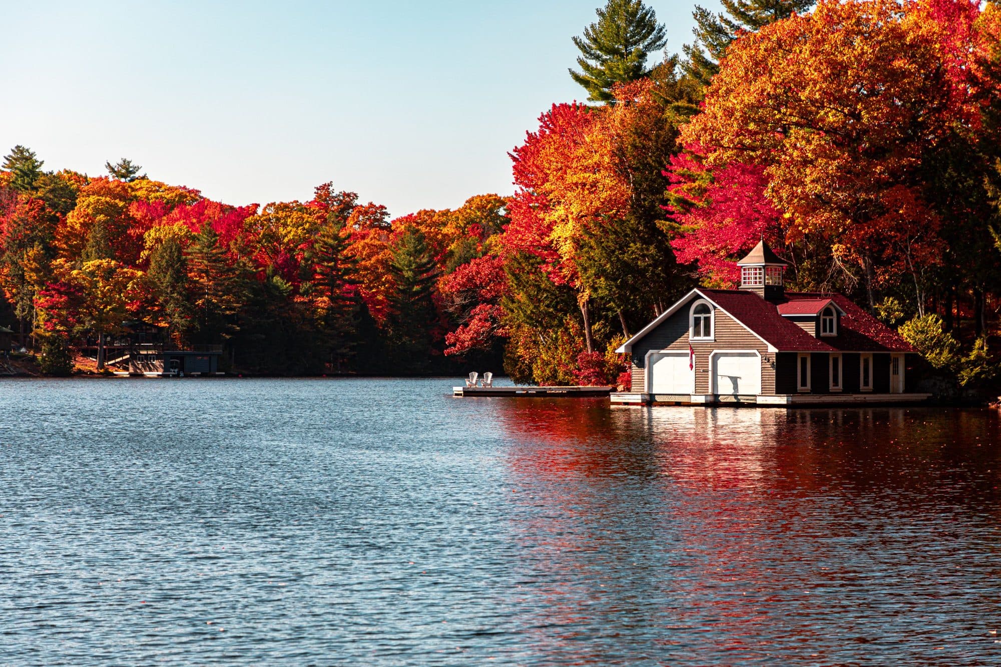Casa de botes en un lago rodeado de árboles de otoño